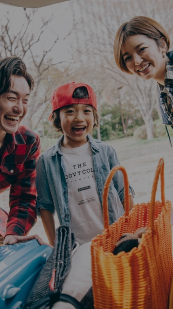 家族が荷物を持ち、子供と共に旅行に出かける準備をしている