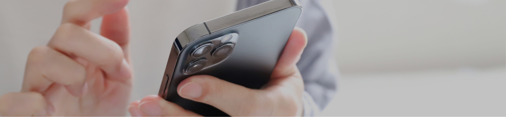 人が親指で携帯電話を持っている